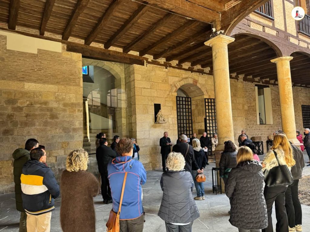 Miembros de la Curia reunidos en el patio del Obispado de León junto a columnas de piedra.